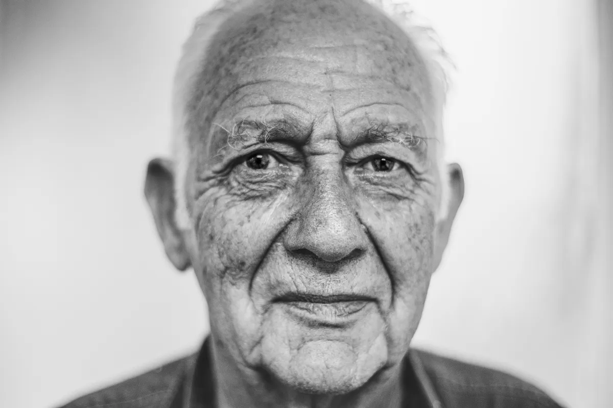 Schwarz-Weiß-Porträt eines älteren Mannes mit ernstem Blick.
